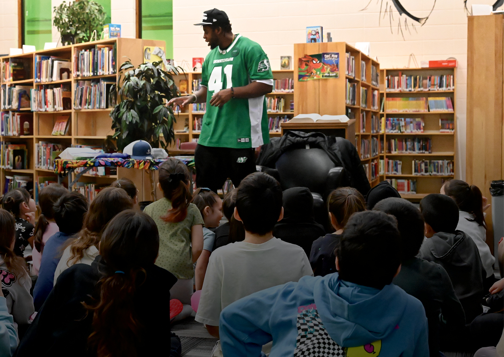 Football player talking to students